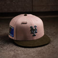 Pink and brown baseball cap with logo and patch on a textured surface
